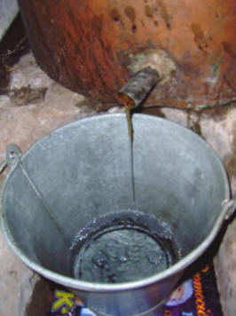 Detalle del régimen de destilación. Se utiliza un mechón de estopa para observar mejor la caída del diminuto chorro. Foto: Abel Domínguez